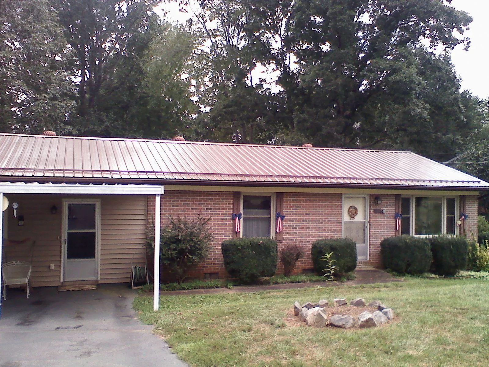 Bronze metal roof and carport on a brick ranch home — Roof Repair work by our crew in Ash Fork